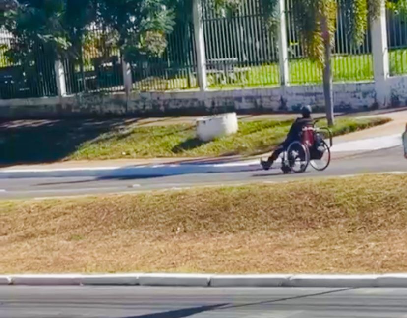 homem usa os pés para impulsionar cadeira de rodas em Cuiabá