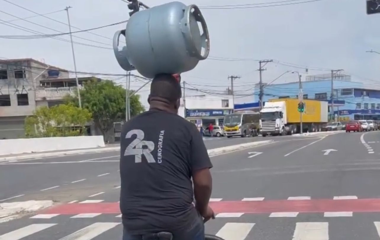 Homem é flagrado equilibrando botijão de gás na cabeça enquanto pedala